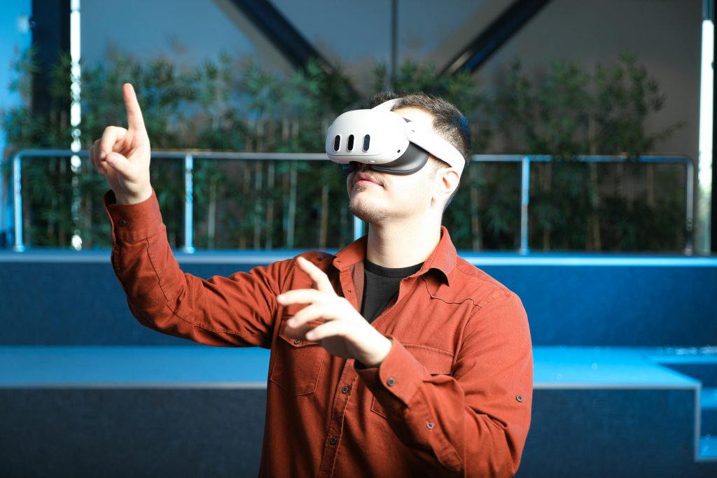 A man wearing a VR headset interacts with augmented reality indoors.